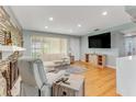 Open living room features hardwood floors, stone fireplace and a large TV at 355 Hartford Ave, Daytona Beach, FL 32118