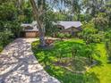 Beautiful single-story home features a paver driveway, lush landscaping, and mature trees at 4073 N Chinook Ln, Ormond Beach, FL 32174