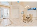 Elegant foyer with tiled floors, decorative glass front door, chandelier, and adjacent dining area at 4427 S Atlantic Ave, Port Orange, FL 32127