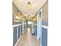 Inviting hallway with tile floors, wainscoting, and decorative lighting at 460 Sarah Nicole Way, New Smyrna Beach, FL 32168