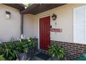 Inviting entryway featuring a bright red door, a 'Welcome' sign and lovely potted plants at 5 Greenfern Cir, Ormond Beach, FL 32174