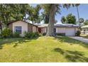 Charming single-story home with a well-maintained lawn and a beautiful shade tree in the front yard at 5 Greenfern Cir, Ormond Beach, FL 32174