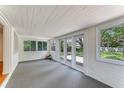 Enclosed sunroom with bright white walls, carpeted flooring, and views of the landscaped backyard at 556 N Beach St, Ormond Beach, FL 32174
