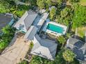 Aerial shot of home highlighting metal roof, canal access, and the inviting backyard swimming pool at 61 E Bayshore Dr, Port Orange, FL 32127