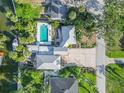 Birds eye view of a property with a pool and canal access, nestled among mature trees and landscaping at 61 E Bayshore Dr, Port Orange, FL 32127