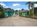 Charming teal home with a pink front door, lush landscaping, and a spacious driveway at 61 E Bayshore Dr, Port Orange, FL 32127