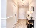 Bright foyer showcasing stylish flooring, wainscoting, and a decorative light fixture at 706 Fox Tail Ct, New Smyrna Beach, FL 32168