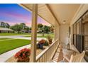 Cozy front porch adorned with vibrant flowers, rocking chairs, and welcoming decor at 928 Chickadee Dr, Port Orange, FL 32127