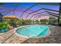 Enclosed pool area with an in-ground pool, brick patio, lounge chairs, and a view of the waterway at 928 Chickadee Dr, Port Orange, FL 32127