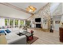 Spacious living room featuring a stone fireplace, vaulted ceilings, and abundant natural light at 96 Hollow Branch Xing, Ormond Beach, FL 32174