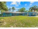 Charming blue single-story home with a manicured lawn and covered carport at 10 Madera Rd, Debary, FL 32713