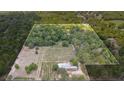 Sprawling property featuring a vineyard, lush landscaping, and mature trees encompassed by a white fence line at 1056 Reynolds Rd, De Leon Springs, FL 32130