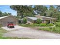 Inviting home with a brick exterior, detached garage, and a vibrant, well-manicured front yard at 1056 Reynolds Rd, De Leon Springs, FL 32130
