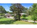 Charming home with a well-maintained lawn and landscape, including a detached garage and a red utility vehicle at 1056 Reynolds Rd, De Leon Springs, FL 32130