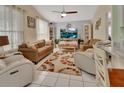 Bright living room features a ceiling fan, window, tile floor, and matching furniture at 1125 Stillwater Dr, Deland, FL 32720