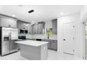 Featuring grey cabinets, a marble countertop island, modern lighting, and stainless steel appliances, this bright kitchen has it all at 1163 W Hancock Dr, Deltona, FL 32725