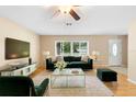 Cozy living room with modern furniture, large windows, and hardwood floors at 1204 Lawrence Ave, Deltona, FL 32725