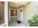 Condo entrance featuring a white door, sidelight window, and blooming plants at 15 Misners Trl, Ormond Beach, FL 32174
