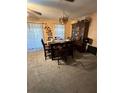 Cozy dining room with hardwood table and chairs, chandelier, and carpeted flooring at 15555 Sw 46Th Cir, Ocala, FL 34473