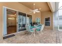 Covered patio with brick pavers, a ceiling fan, and a table with four chairs at 1910 Creekwater Blvd, Port Orange, FL 32128