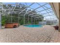 Relaxing screened-in pool area, with a hot tub and brick pavers at 1910 Creekwater Blvd, Port Orange, FL 32128