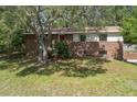 Charming brick two-story home with a well-maintained front yard and mature trees at 2032 Yorkshire Dr, Deland, FL 32724