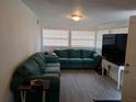 Inviting living room with a comfortable green sectional sofa and ample natural light at 20422 Canvas Back Rd, Altoona, FL 32702