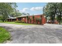 This is a beautiful property with brick walls, landscaping, and a barn in the background at 2221 Oak Hill Dr, Deland, FL 32720
