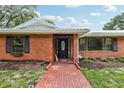 Close-up view of a beautiful brick home and brick walkway leading to the front door at 2221 Oak Hill Dr, Deland, FL 32720