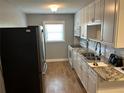 Updated kitchen with stainless steel appliances, granite countertops, and white cabinets at 233 Elmwood Ave # 290, Deland, FL 32724