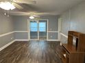 Spacious living room with wood floors, neutral walls, ceiling fans, and sliding glass doors at 233 Elmwood Ave # 290, Deland, FL 32724