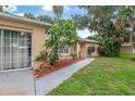 Inviting entrance with a well-manicured lawn and landscaping leading to the front door at 2509 Kumquat Dr, Edgewater, FL 32141