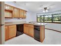 Well-lit kitchen with black appliances, bright wood cabinets, and a central island, complemented by a window at 2699 Audubon Ave, Deland, FL 32720