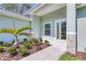 Welcoming front entrance showcasing a well-manicured garden and a modern glass-paneled door, creating a warm ambiance at 2894 Hardy Ave, New Smyrna Beach, FL 32168