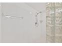 Clean, white tiled shower with glass block and chrome fixtures at 3315 S Atlantic Ave # 1406, Daytona Beach Shores, FL 32118