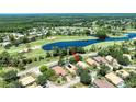 An aerial view of the property with a golf course and pond in the background at 438 Harbour Town Ln, Ormond Beach, FL 32174