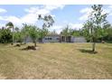 Charming single-story home with mature landscaping and a bright red front door at 45 S University Cir, Deland, FL 32724