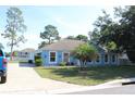 Light blue home with white trim, well-maintained landscaping, and long concrete driveway at 4611 Se 32Nd Pl, Ocala, FL 34480