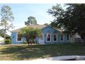 Inviting single-story home features a well-maintained lawn and lush landscaping with a palm tree in the front yard at 4611 Se 32Nd Pl, Ocala, FL 34480