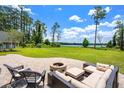 Patio with comfortable seating and firepit, perfect for entertaining with a view of the lake at 5366 N Lake Farms Rd, De Leon Springs, FL 32130