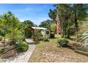 Backyard with garden shed, arbor and mature landscaping and American flag at 5635 Burts Park Rd, De Leon Springs, FL 32130