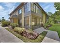 Stylish condo building with large windows and a covered patio, surrounded by well-manicured landscaping at 600 N Boundary Ave # 118B, Deland, FL 32720