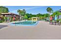 Community pool with lounge chairs, umbrellas, and a nearby cabana for relaxation and recreation at 600 N Boundary Ave # 118B, Deland, FL 32720