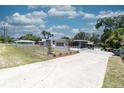 A wide view of home with a concrete driveway and chain-link fence surrounding the property at 601 Berkshire Rd, Daytona Beach, FL 32114