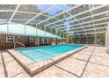 Beautiful screened-in pool with brick surround and covered patio area, perfect for entertaining at 712 S Timberlane Dr, New Smyrna Beach, FL 32168