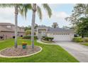 Attractive single-story home showcasing lush landscaping, mature trees, and a convenient two-car garage at 723 Oakwater Ln, Port Orange, FL 32128