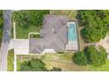 Aerial view of home showcasing in-ground screened pool, well-maintained yard and surrounding trees at 980 Marjorie Rawlings Dr, Deland, FL 32720