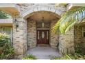 Inviting front entryway with brick archway and decorative wood door at 980 Marjorie Rawlings Dr, Deland, FL 32720