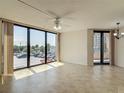 Sunlit living room featuring tiled floors and large sliding glass doors to the balcony at 1 Oceans West Blvd # 2A1, Daytona Beach, FL 32118