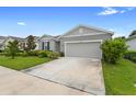 Street view of a well-maintained one-story home, featuring manicured landscaping and a two-car garage at 1002 River Falls Cir, Deland, FL 32720